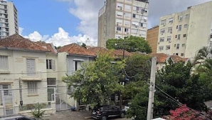Un balcon donnant sur une rue résidentielle, avec vue sur les voitures garées et les immeubles.