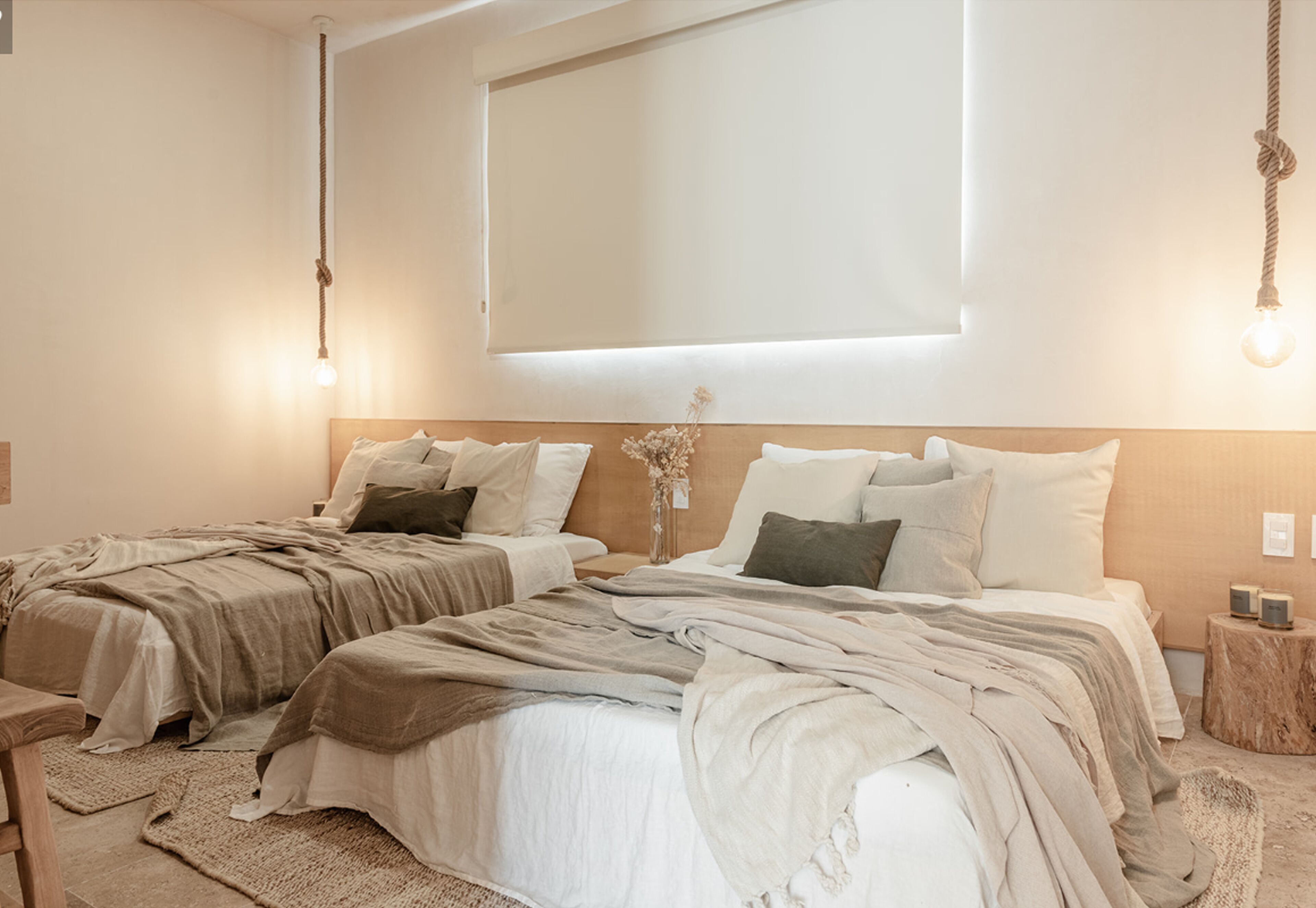 Ein Schlafzimmer mit zwei Betten, einem großen Fenster und einem Nachttisch mit Lautsprechern.