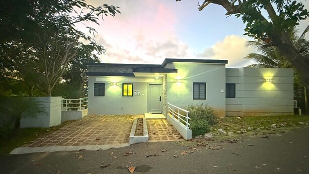Uma casa moderna de dois andares com um caminho de entrada pavimentado e um pequeno alpendre.