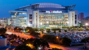 Un estadio con la señalización 'NRG Stadium', rodeado de estacionamientos y calles.