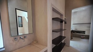 A bathroom with a white sink, a mirror, and three black shelves. - Apsara Villas perfect oasis in Tulum (Tulum)