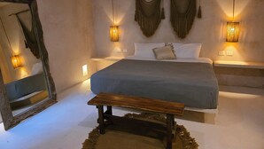 A bedroom with a large bed, bedside tables, a mirror, and hanging macramé wall decorations. - Apsara Villas perfect oasis in Tulum (Tulum)
