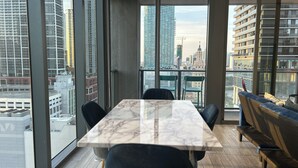 Een moderne vergaderruimte met een marmeren tafel en zwarte stoelen, grote ramen met uitzicht op de stad.
