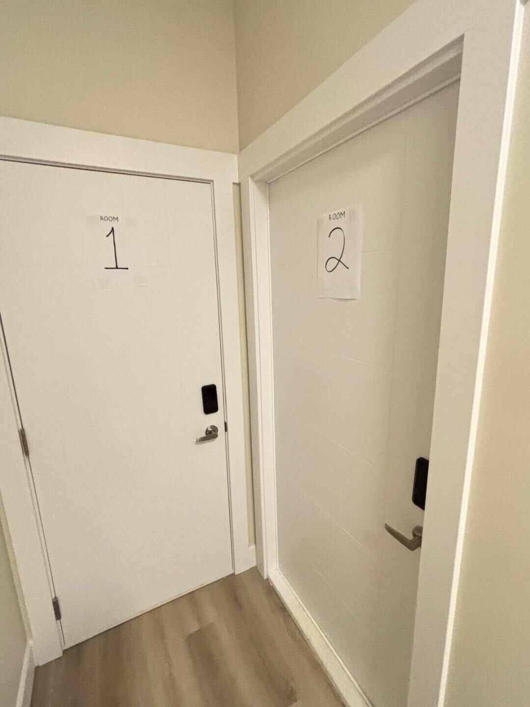 A hallway with two doors labeled "ROOM 1" and "ROOM 2".
