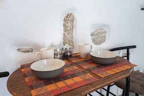Ein Tisch mit zwei Schalen, zwei Tassen und zwei Gläsern, beschriftet mit 'Zucker' und 'Kaffee', auf einer karierten Tischdecke.