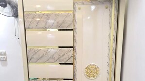 Een kast met een marmer dessin en gouden details.
