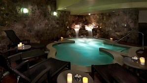 Un espace de détente avec un jacuzzi, des chaises longues et une cascade.