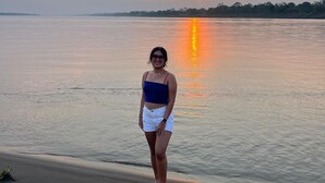 A person standing by a calm body of water during sunset. - Milia Amazon Lodge (Iquitos)