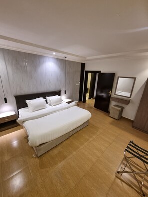 A modern hotel room with a large bed, bedside tables, a mirror, and a wardrobe. - افاق سويت المصيف للشقق المخدومة - Afaq Suite Al Massif Serviced Apartments (Riyadh)