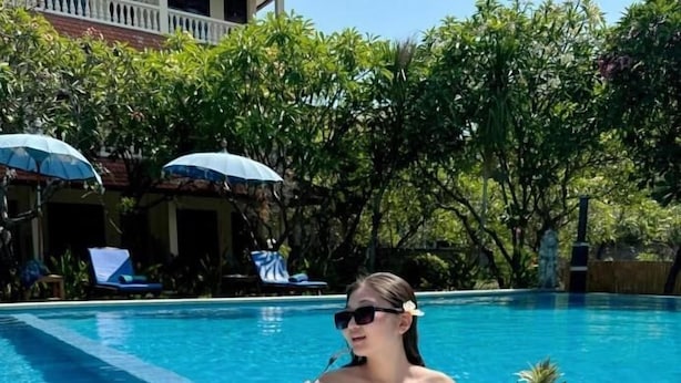 A poolside breakfast setup with a wicker table, food, drinks, and a tropical setting. - New Mekar Jaya Hotel (Kuta)