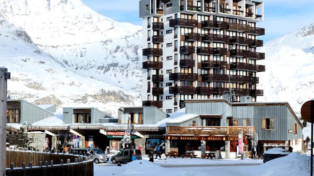 A modern hotel with multiple floors, balconies, and a view of snow-covered mountains. - Apartment in Tignes With Ski-in Ski-out (Tignes)