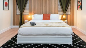 A hotel room with a bed, two bedside tables, a lamp, and a framed picture on the wall. - Luxe Disneyland Multi-Family Villa • King Beds • Game Rooms • EV • Sleeps 28 (Santa Ana)