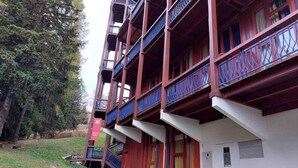 A multi-story building with balconies, a grassy area, and a red sign. - Duplex for 5 People in the Village of Charmettoger in Les Arcs 1800 - Residence at the Foot of the Slopes (Bourg-Saint-Maurice)