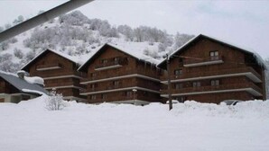 A row of wooden cabins with balconies, surrounded by snow-covered ground and trees. - Apartment in Les Verneys Near Ski Lift (Valloire)