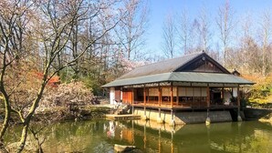 A traditional Japanese building with a wooden exterior, a tiled roof, and a reflection in the water. - Holiday Home in the Heart of Hasselt (Hasselt)