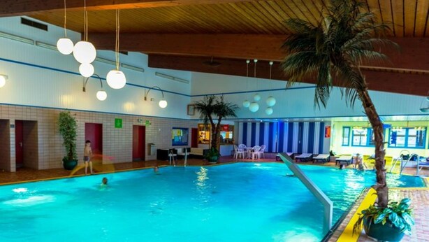 An indoor swimming pool with multiple lanes, surrounded by lounge areas and a wooden ceiling. - House Sunshine on the ski Slope (Herrischried)