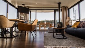 A modern living room with a sofa, chairs, a coffee table, and a TV. - Floating Houseboat in Peenemunde (Peenemünde)