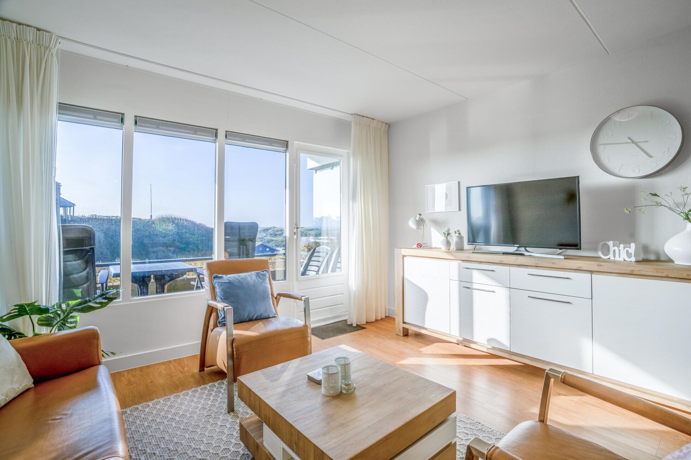 Ein modernes Wohnzimmer mit Sofa, Couchtisch und Fernseher.