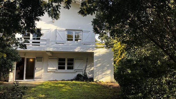 A two-story house with a white exterior, a front door, and a small porch. - Villa Near Beach With Large Garden (Biscarrosse)