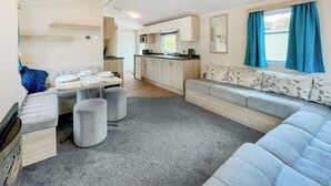 Un espacio habitable compacto con kitchenette, comedor y sofá.