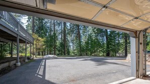 Un área de estacionamiento techada con vista a una zona boscosa.