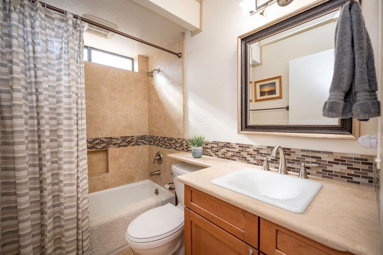 Une salle de bain équipée d’une douche, de toilettes, d’un lavabo et d’un miroir.