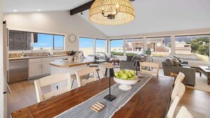 Une cuisine spacieuse avec un coin repas, de grandes fenêtres et une vue sur le paysage.