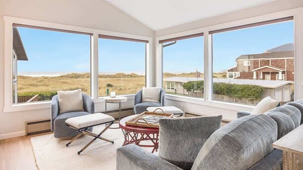 Une pièce spacieuse avec de grandes fenêtres, un coin salon confortable et une vue sur le paysage.