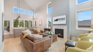 Amplia sala de estar con chimenea, comedor y vistas al exterior.