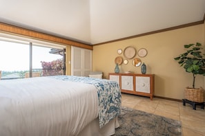 A bedroom with a bed, a dresser, a large window, and a plant. - Kapalua Golf | Golf View 5 BR, Sleeps 16 | Car Incl. w/ 6+ Nights | KGV ML-2321 by KBM (Lahaina)