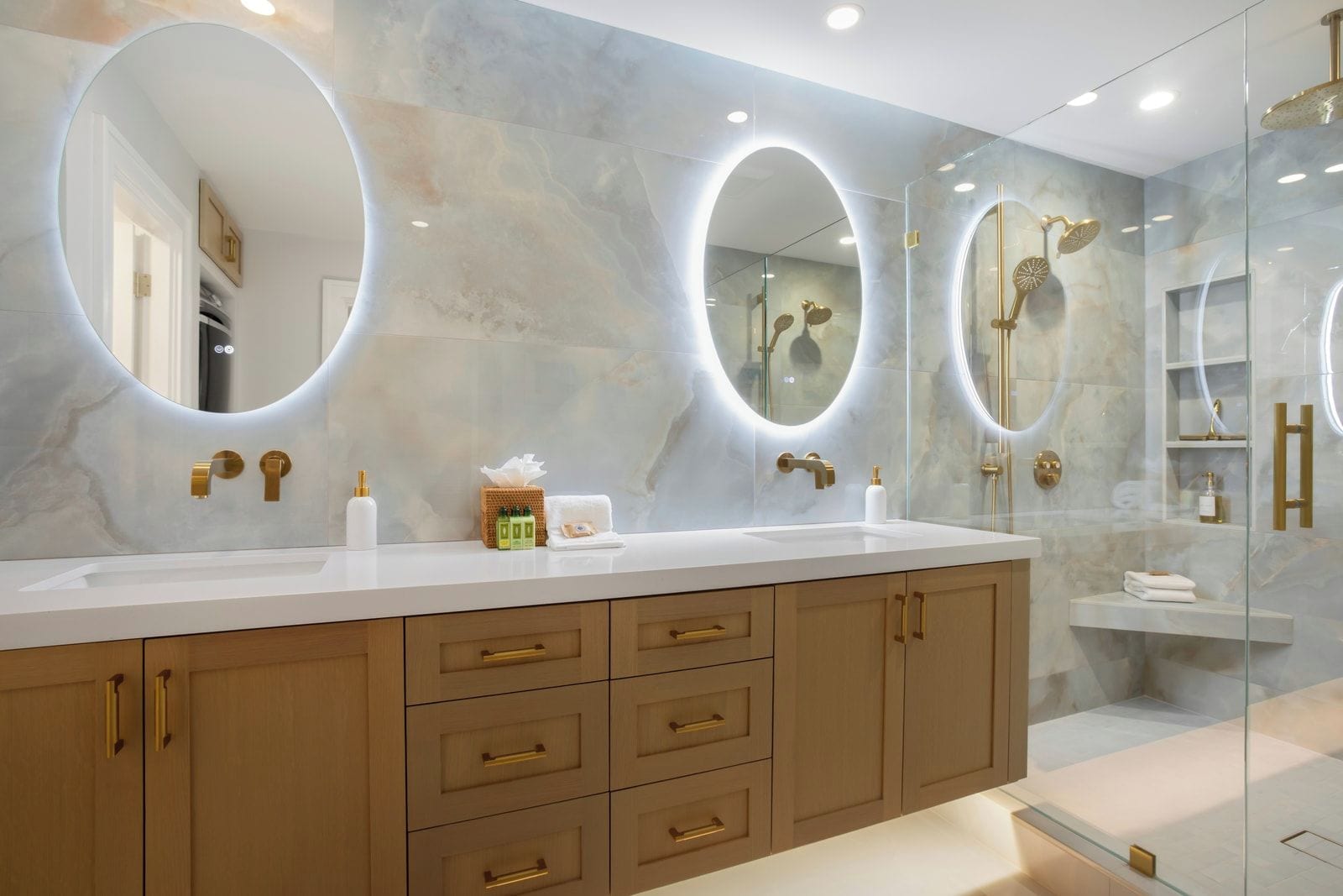 A modern bathroom with two sinks, large mirrors, and a glass-enclosed shower area.