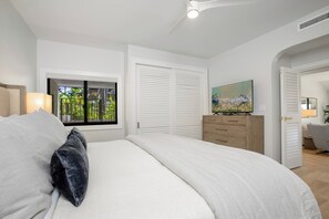 A bedroom with a bed, a window with a view, a dresser, and a painting on the wall. - Kapalua Golf | Golf View 5 BR, Sleeps 15 | Car Incl. w/ 6+ Nights | KGV ML-2333 by KBM (Lahaina)