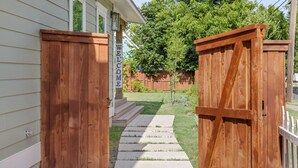 A wooden gate with a 'WELCOME' sign, leading to a house with a front porch and a lawn. - Spacious Modernized Historic Home 3 Minute Walk from Square (Georgetown)