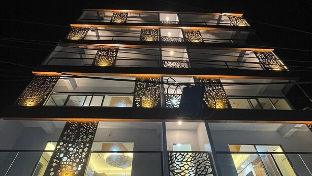 A multi-story building with a modern design, featuring balconies with decorative railings and a glass facade. - Hotel Sonar Bangla Rangamati (Rangamati Sadar)