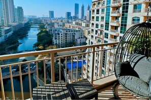 A balcony with a view of a river and cityscape, including modern buildings and a bridge. - Luxe 1-BR w/ Sunset, Golf & Lake View in The Greens (The Greens)