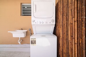 A front-loading washing machine with a control panel and a label indicating energy efficiency. - SunJoy No.5 - Chic 2BR Apartment Isla Verde (Carolina)