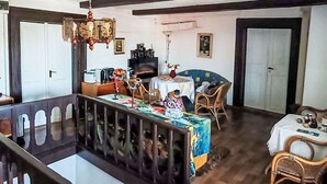 A dining area with a table set for two, a television, and a fireplace. - Stunning  villa for 4 people with WIFI, pool, TV and pets allowed (Rumburk)