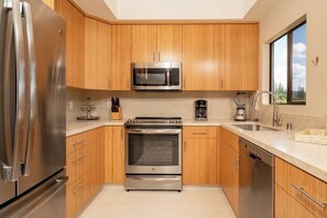 Stainless steel, warm wood, and natural light combine in this stylish kitchen built for beauty and function KGV-19T1 - Kapalua Golf | Golf View 6 BR, Sleeps 19 | Car Incl. w/ 6+ Nights | KGV ML-2411 by KBM (Lahaina)