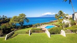 A pool with a view of the ocean and a mountain in the distance. - Napili Point | Oceanfront 3 BR, Sleeps 10 | Car Incl. w/ 6+ Nights | NAP ML-2438 by KBM (Lahaina)