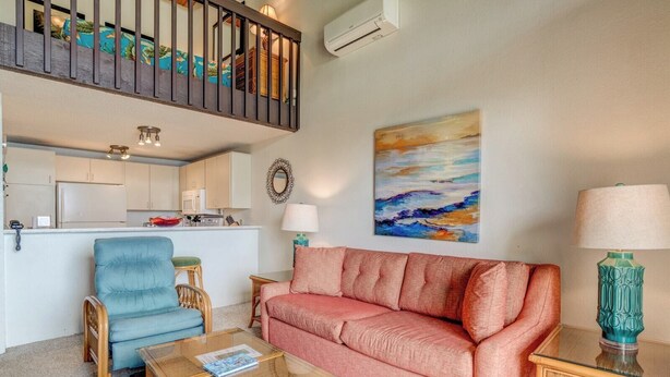 A living room with a sofa, a chair, a coffee table, a lamp, and a painting on the wall. - Napili Point | Oceanfront 3 BR, Sleeps 10 | Car Incl. w/ 6+ Nights | NAP ML-2438 by KBM (Lahaina)