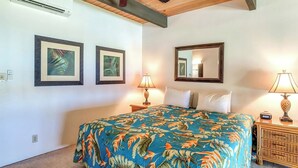 A bedroom with a bed, two wall-mounted lamps, a ceiling fan, and two framed pictures. - Napili Point | Oceanfront 3 BR, Sleeps 10 | Car Incl. w/ 6+ Nights | NAP ML-2438 by KBM (Lahaina)
