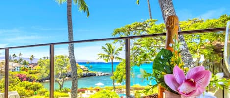 Un balcone con vista su una spiaggia tropicale e sull'oceano.