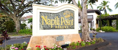A sign for Napoli Point Resort with a stone base and a marble top.