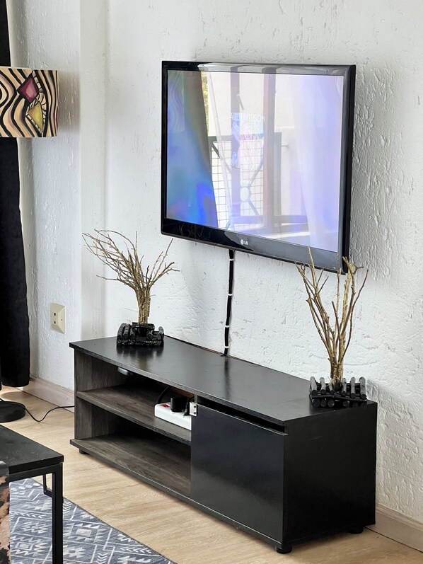 A modern living room with a flat-screen TV mounted on a black entertainment unit. - Serene, Bryanston + free pizza (Sandton)