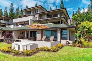 A multi-story house with a covered patio, outdoor seating, and a well-maintained garden. - Kapalua Golf | Golf View 3 BR, Sleeps 9 | Car Incl. w/ 6+ Nights | KGV ML-2204 by KBM (Lahaina)