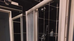 A modern bathroom with a glass-enclosed shower, a white sink, and a mirror above the sink. - Charming 1BR Apartment In Top Location (Vienna)