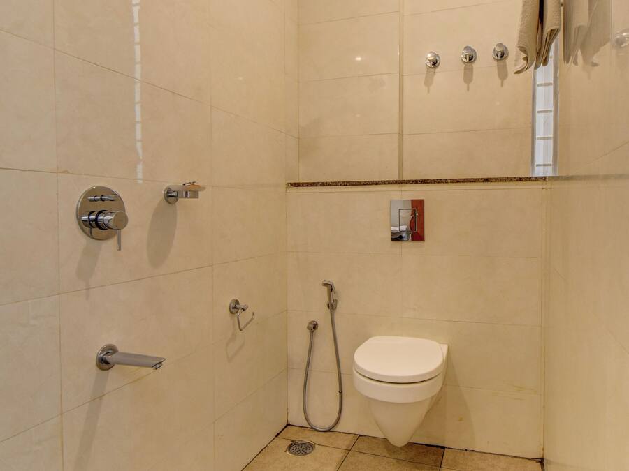 Un baño pequeño con azulejos, inodoro, ducha e lavamanos.