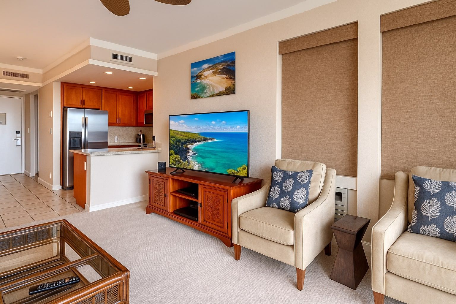 A living room with a TV, a sofa, a chair, a coffee table, and a kitchen area.