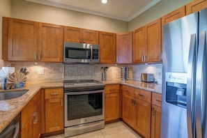 The warmth of the wood, the sleek appliances—this kitchen is where style meets everyday convenience KGV-16T4 - Kapalua Golf | Golf View 4 BR, Sleeps 10 | Car Incl. w/ 6+ Nights | KGV ML-2237 by KBM (Lahaina)