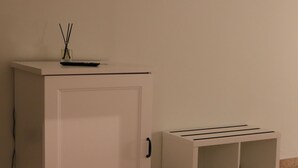 A white cabinet with a flat-screen TV on top and a small vase with reed sticks. - La casetta di Fra & Giu (Longobucco)